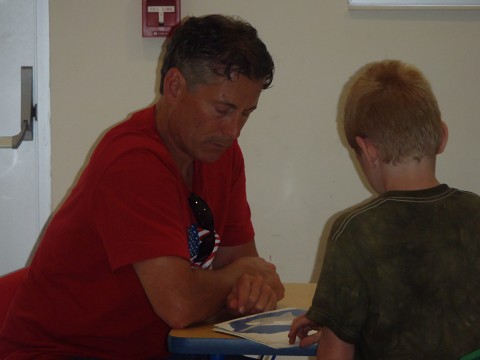 Ed reading to a young man at the Boys and Girls Club